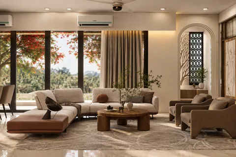 Living room, Gulmohar House. Floor-to-ceiling glass onto the gulmohar canopy, a low sofa with a leather chaise, and an arched niche screened by a jaali.