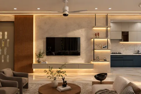 Family room, Gulmohar House. A limewashed media wall over a cove-lit floating console, fluted walnut and shelves hung from the ceiling.