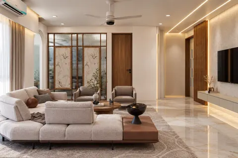 Lounge, Gulmohar House. A deep sectional on a patterned rug, a reeded-glass screen with painted bird panels, and a line of light along the ceiling.